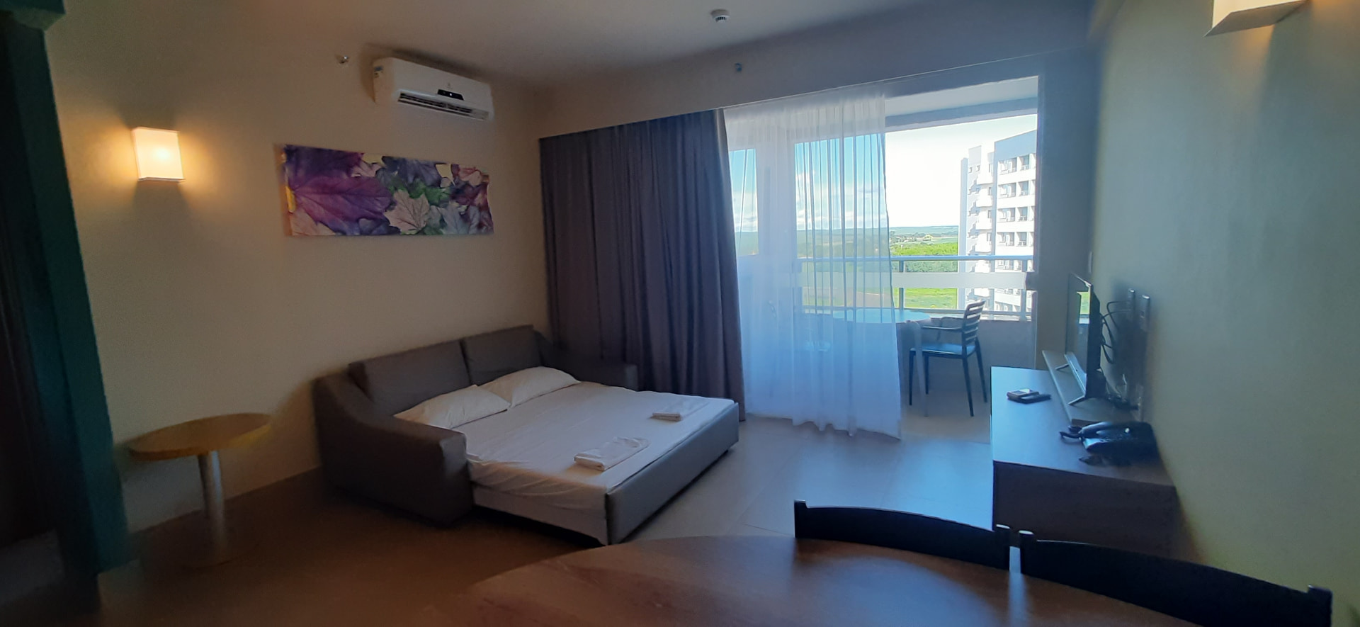 Sofá-cama aberto na sala com vista para a varanda