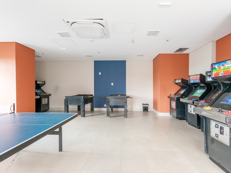 Sala de jogos com fliperamas, pebolim e tênis de mesa