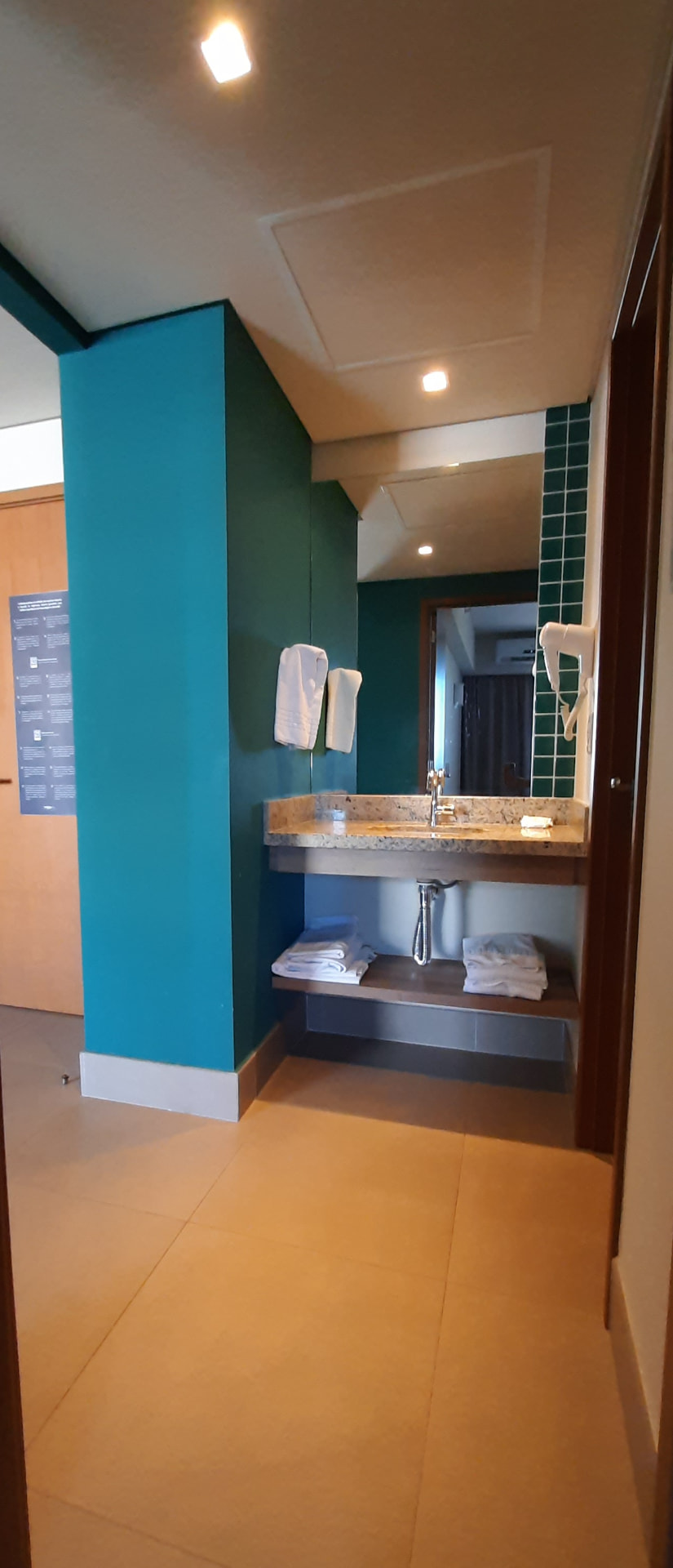 Corredor do apartamento com pia externa e espelho